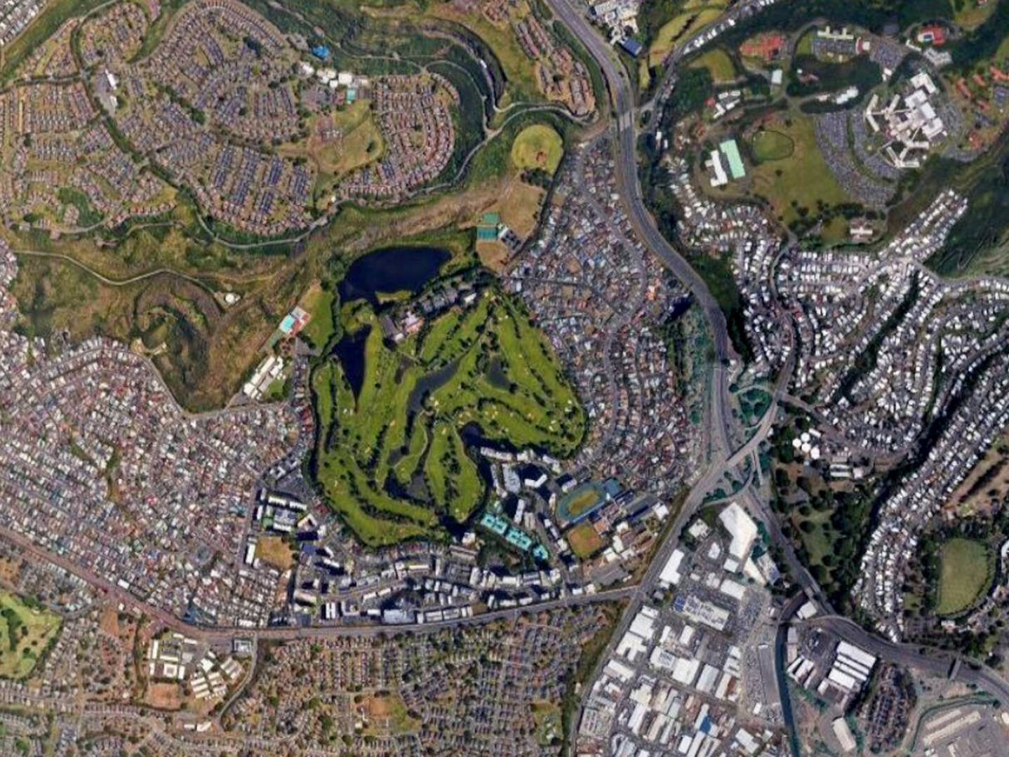 A satellite view of Oahuʻs Salt Lake, showing a golf course, surrounding neighborhoods, and the slope of nearby mountains