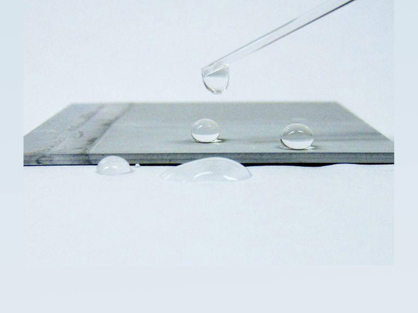 A metal surface with water droplets on the surface
