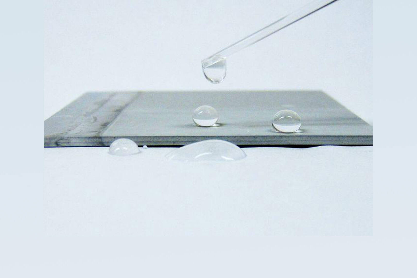 A metal surface with water droplets on the surface