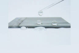 A metal surface with water droplets on the surface