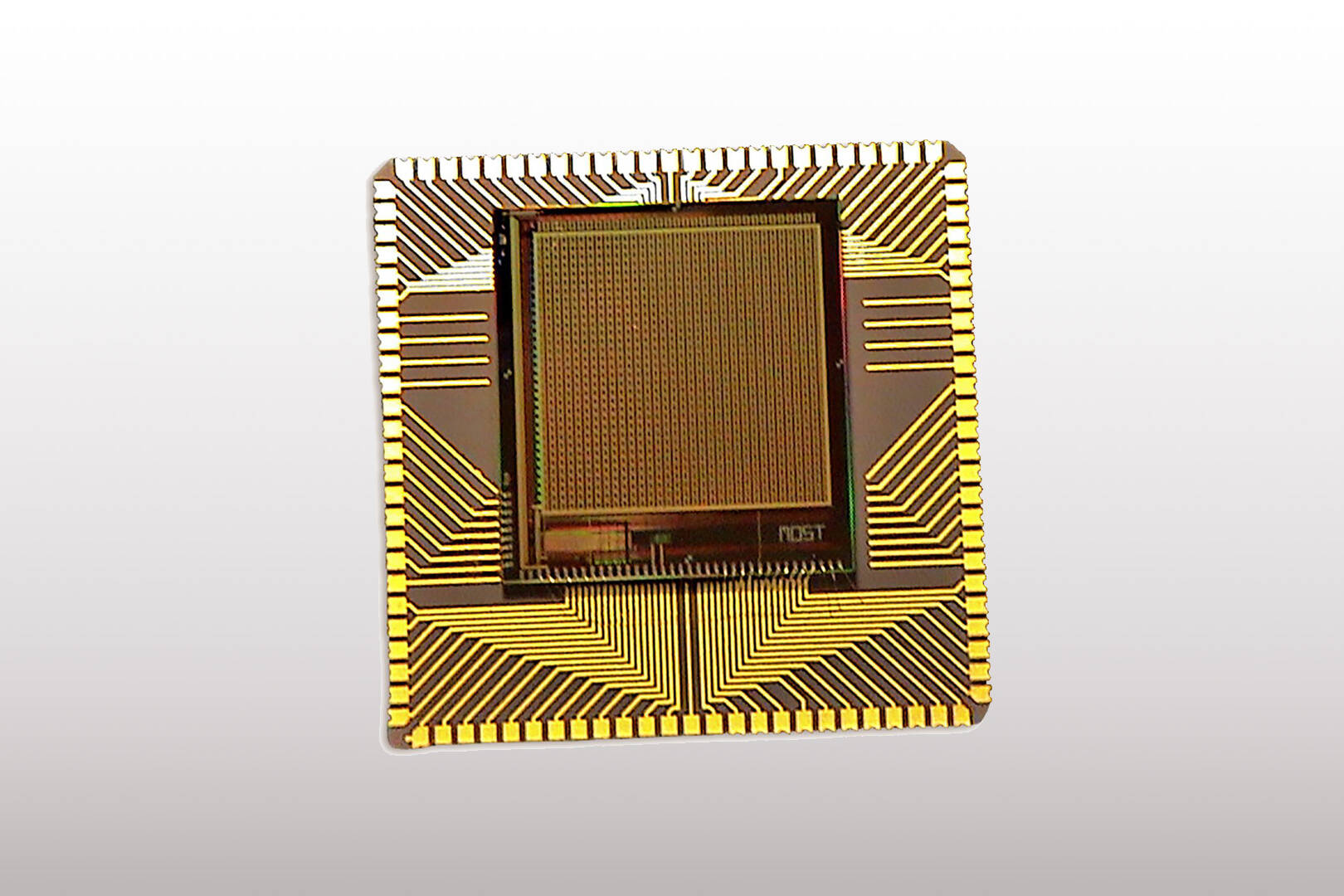 A gold colored computer chip on a white background