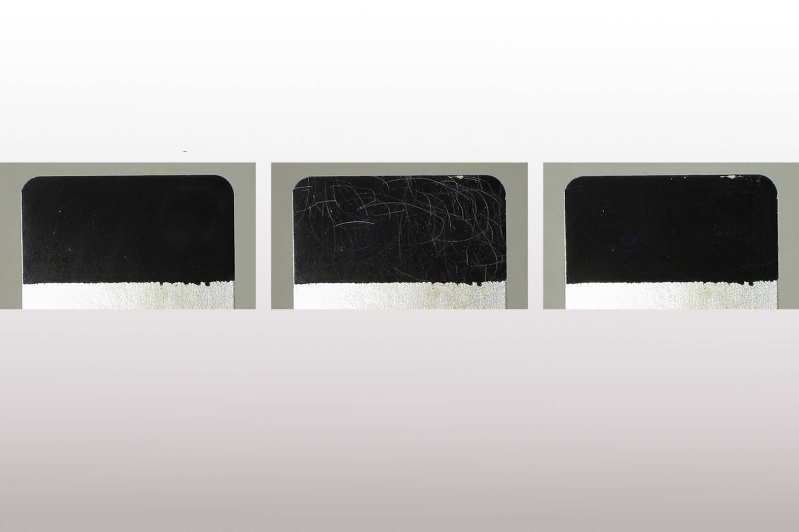 Three metal coupons with various stages of scratches.