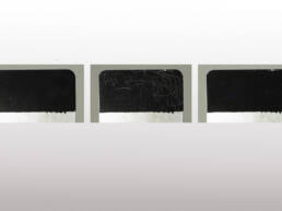 Three metal coupons with various stages of scratches.