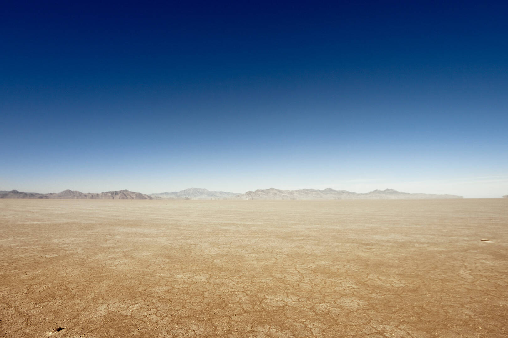 A vast desert landscape with mountains on the horizon