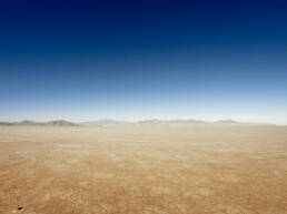 A vast desert landscape with mountains on the horizon