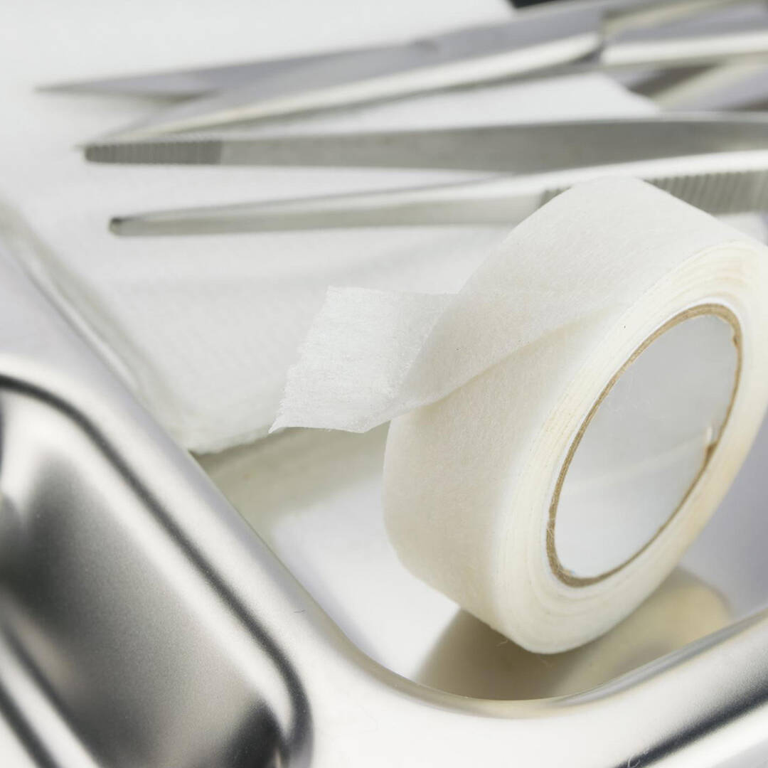 A close up of a silver tray with medical tape
