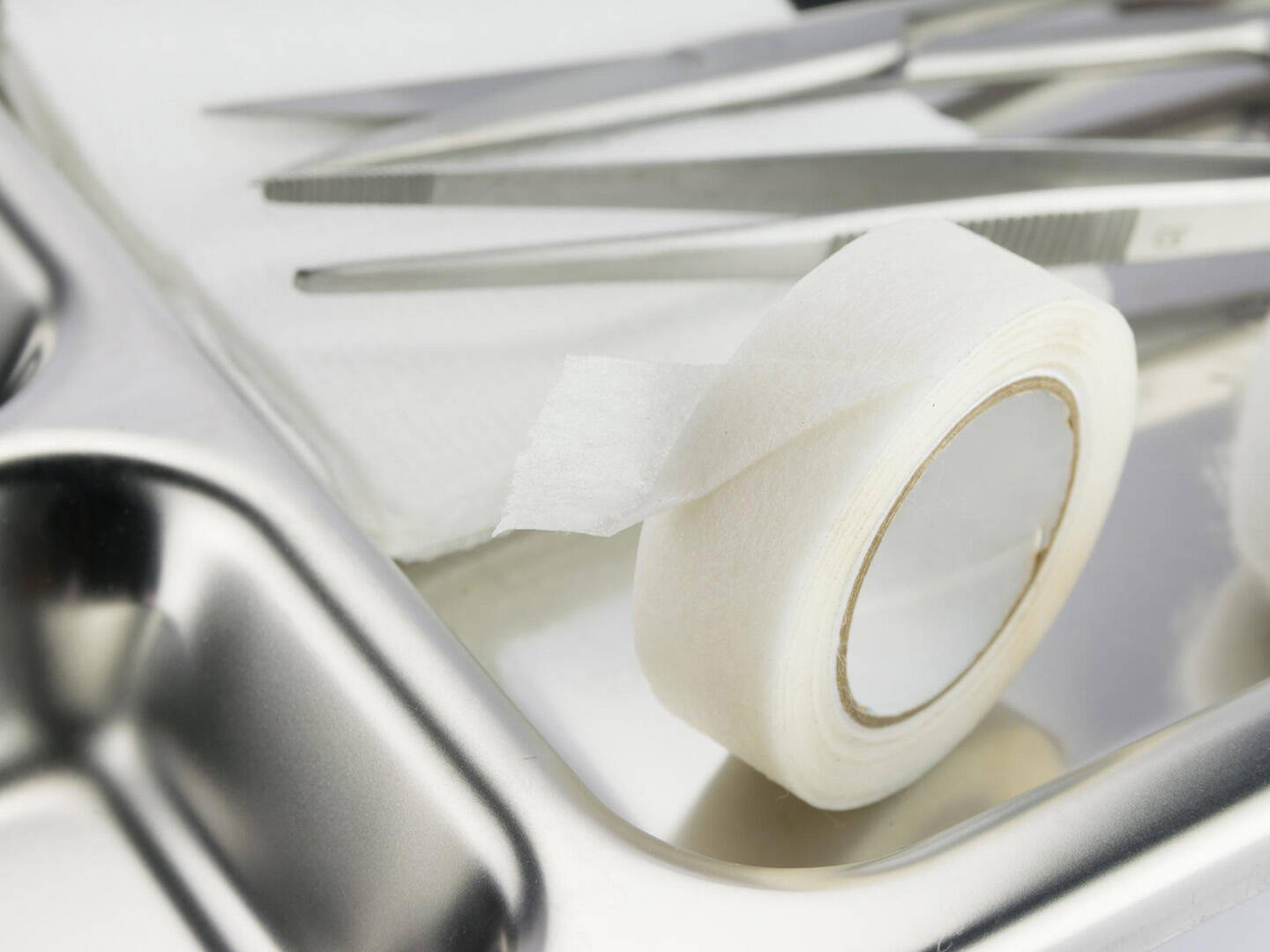 A close up of a silver tray with medical tape