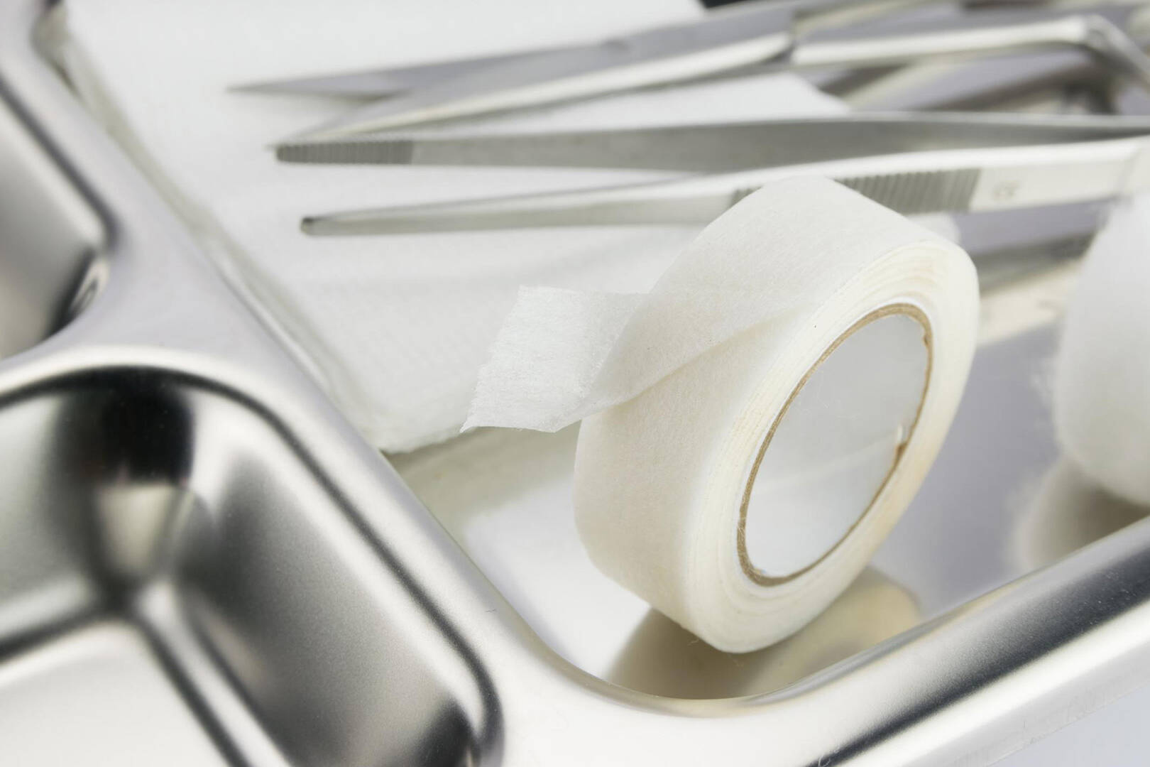 A close up of a silver tray with medical tape