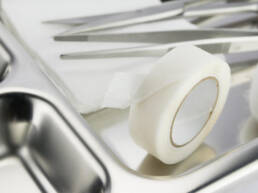 A close up of a silver tray with medical tape