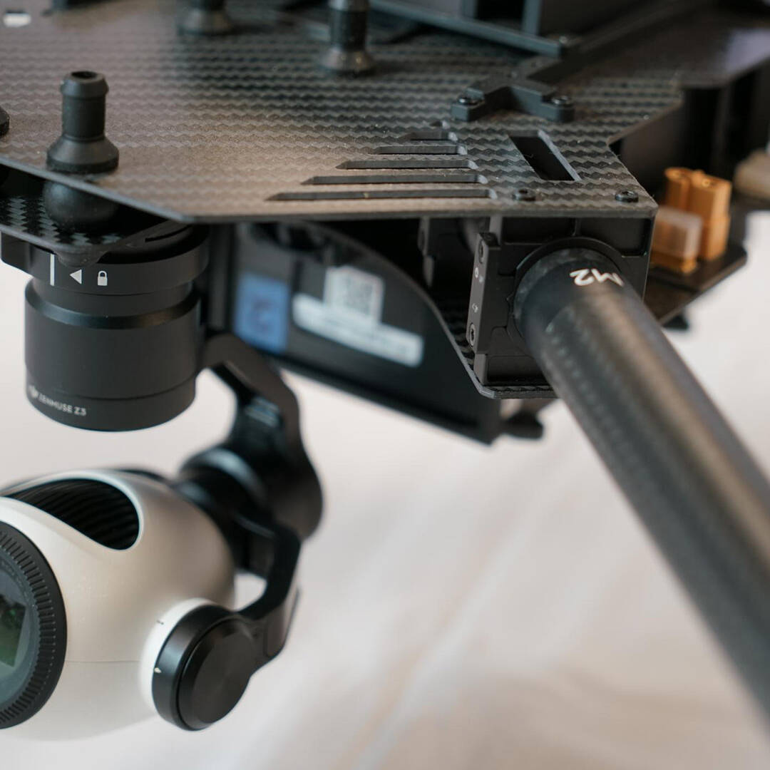 A white, round camera attached to a black rig