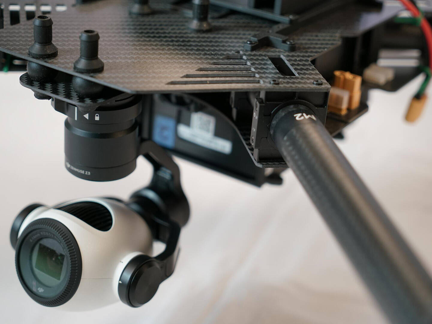 A white, round camera attached to a black rig