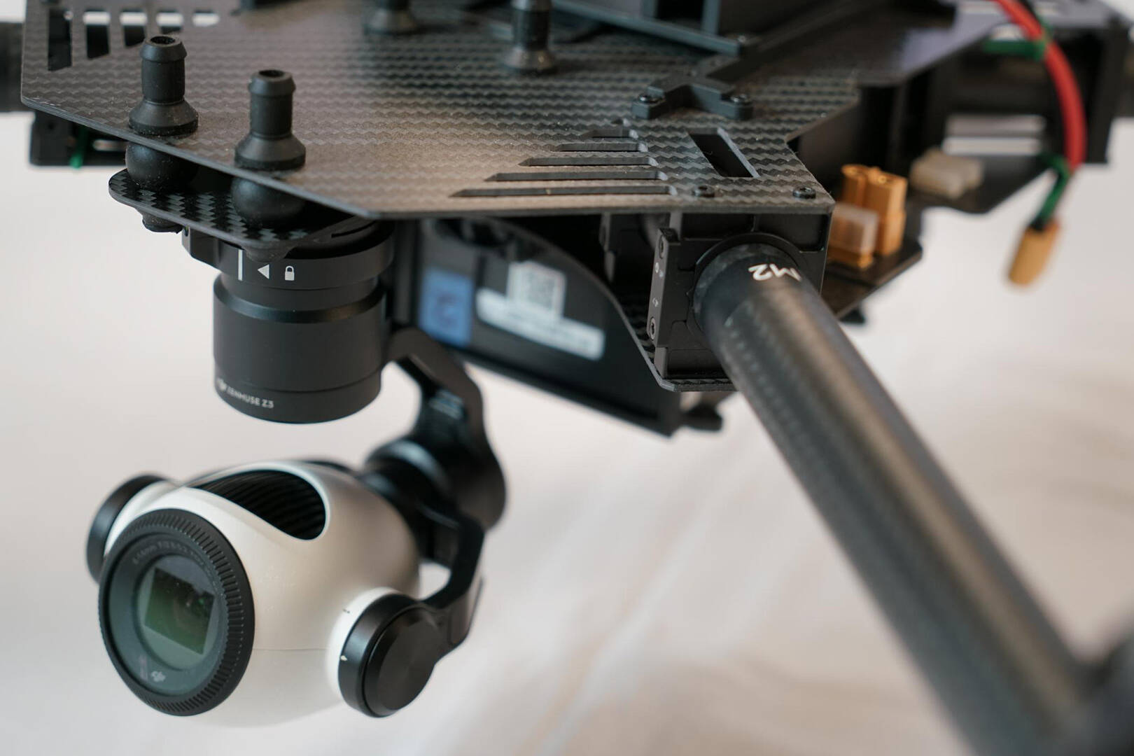 A white, round camera attached to a black rig