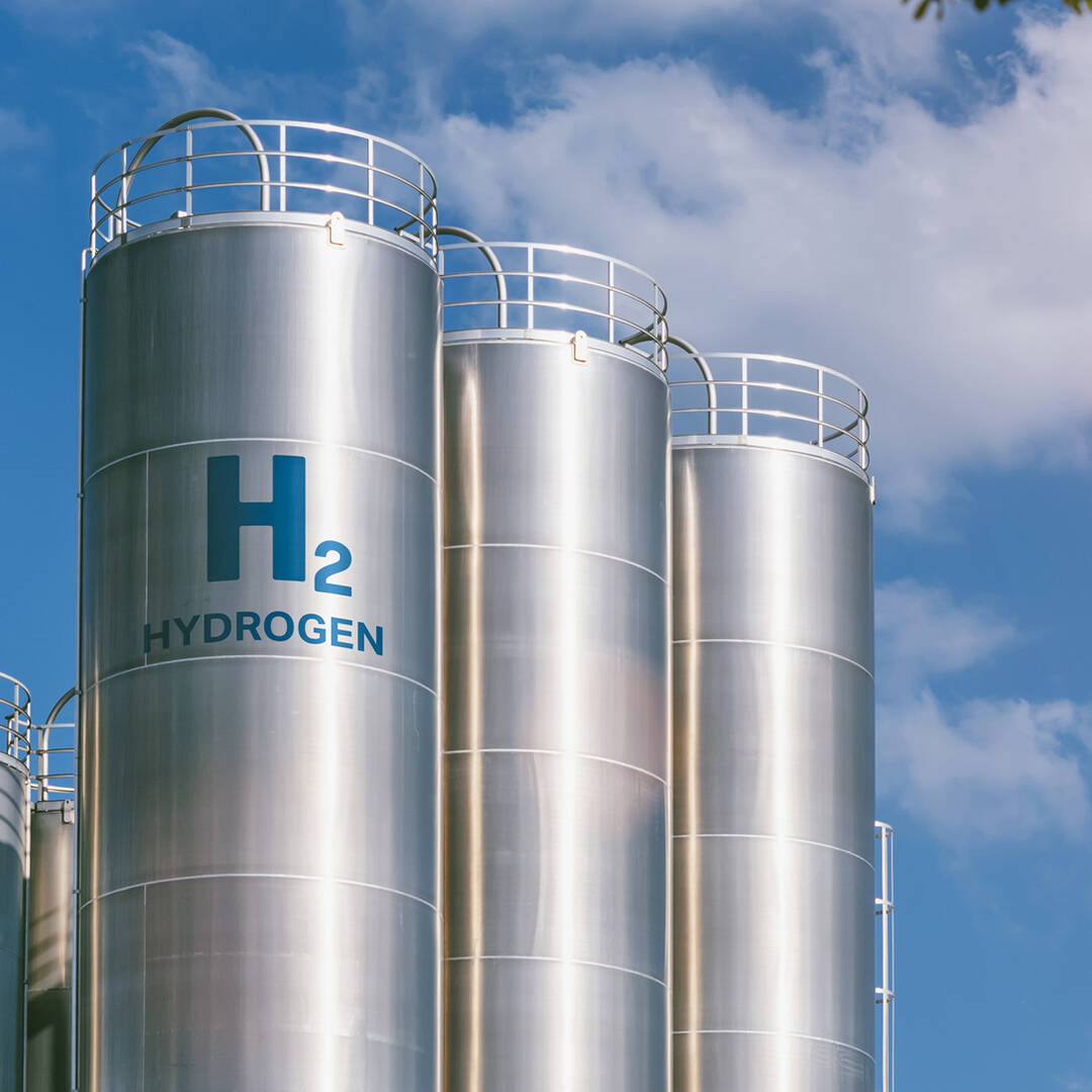Silver silos containing hydrogen against a blue sky
