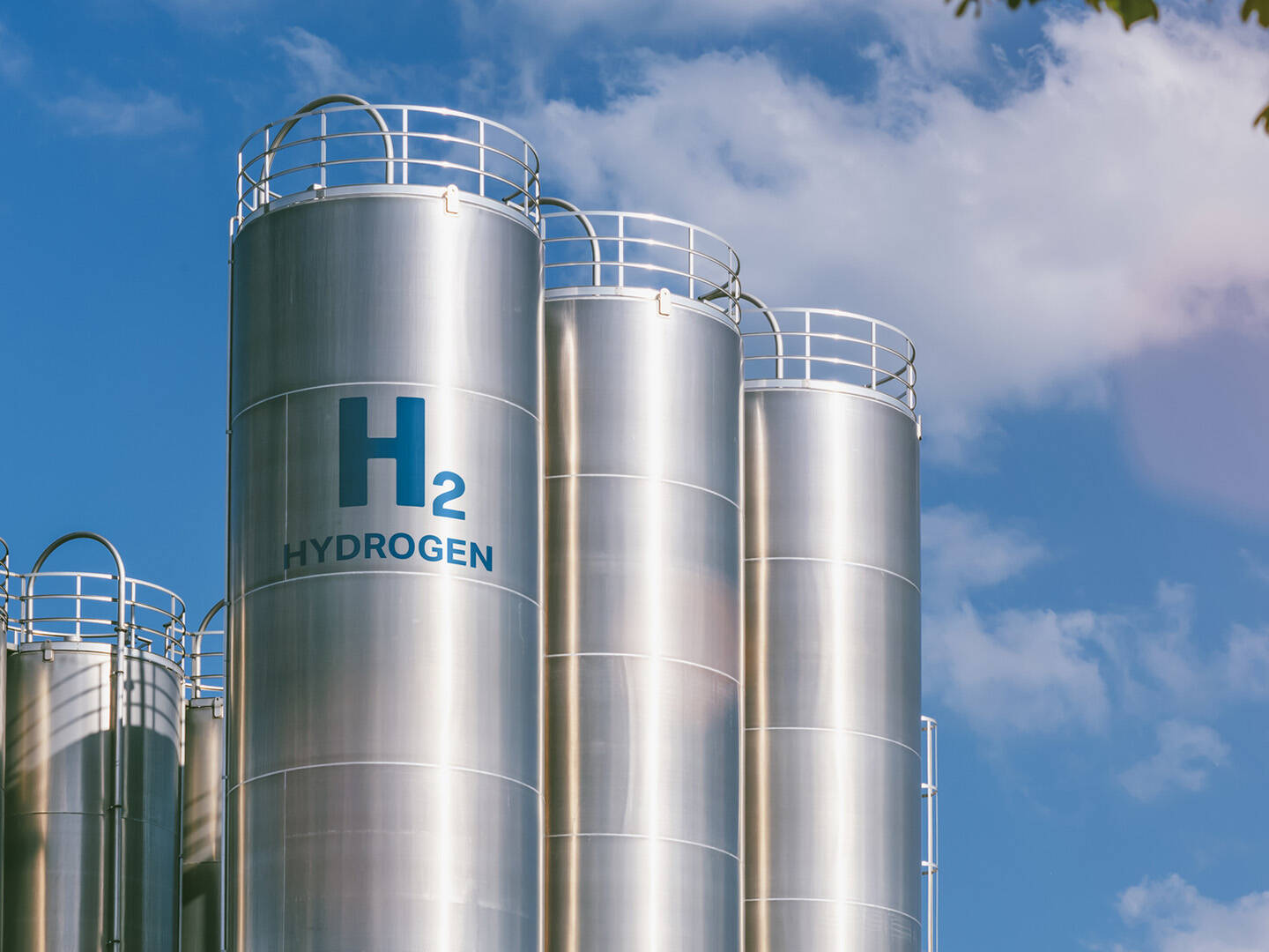 Silver silos containing hydrogen against a blue sky