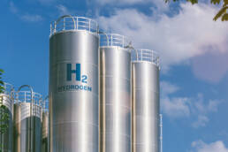 Silver silos containing hydrogen against a blue sky