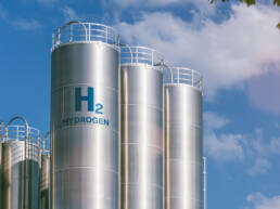 Silver silos containing hydrogen against a blue sky