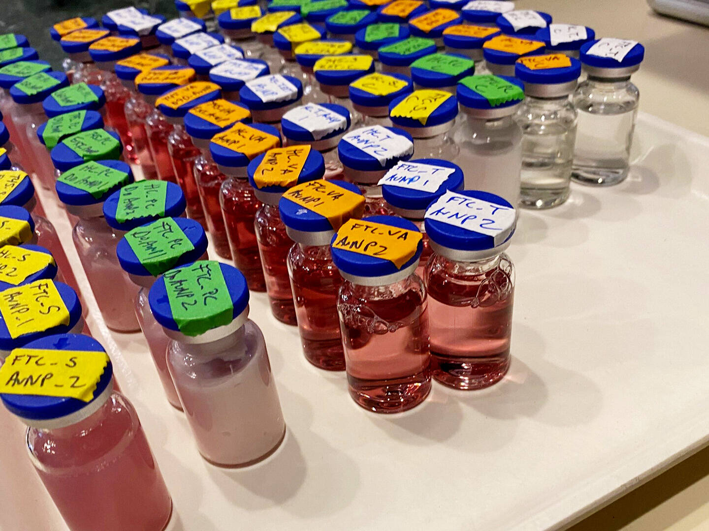 A tray filled with vials with colorful liquid inside