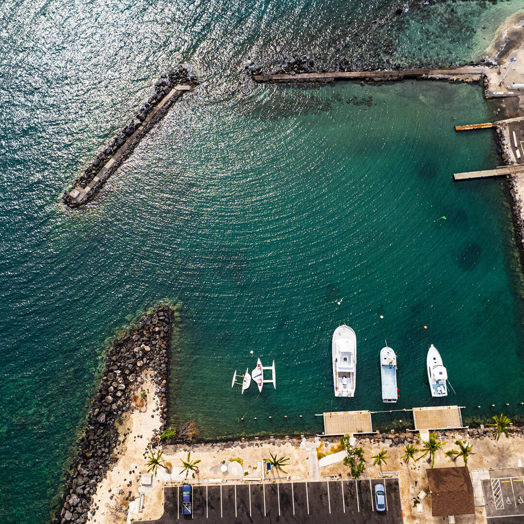 An ariel view of a harbor with small boats on dark blue water