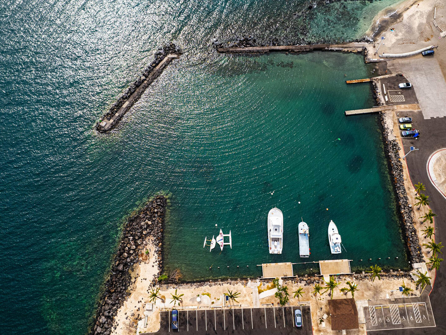 An ariel view of a harbor with small boats on dark blue water