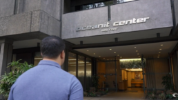 A photo of the back of a man's head while he walks into the Oceanit Center building