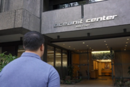 A photo of the back of a man's head while he walks into the Oceanit Center building