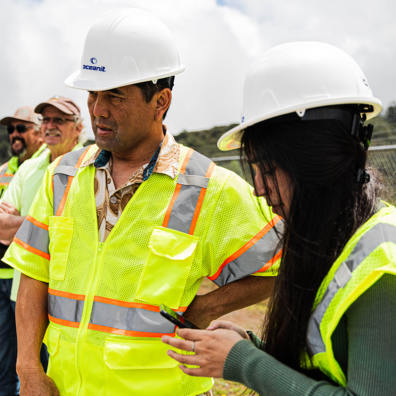 Oceanit employees in hard hats and safety vests overseeing a work site