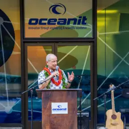 Pat Sullivan speaking at a podium outside the Oceanit headquarters