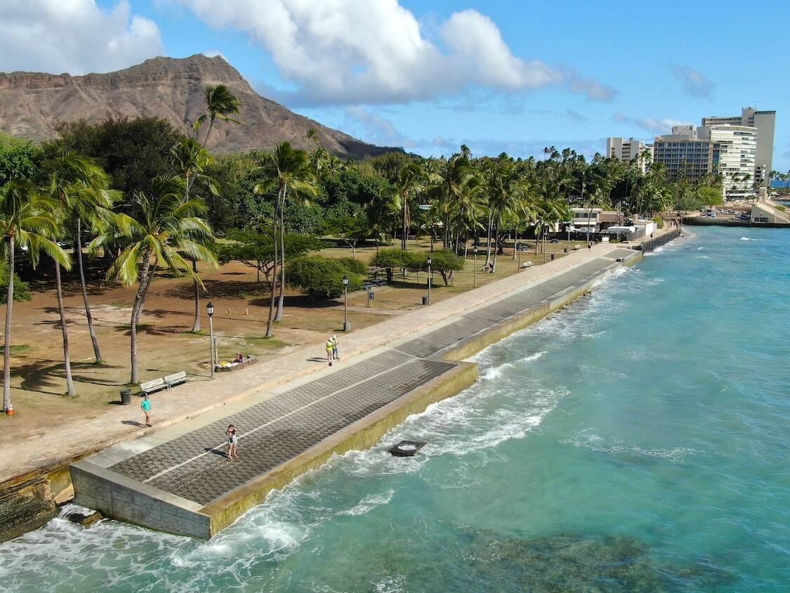 The Queens Beach Waikiki shoreline with an installed seawall and Diamond Head in the background