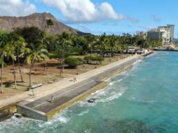 The Queens Beach Waikiki shoreline with an installed seawall and Diamond Head in the background