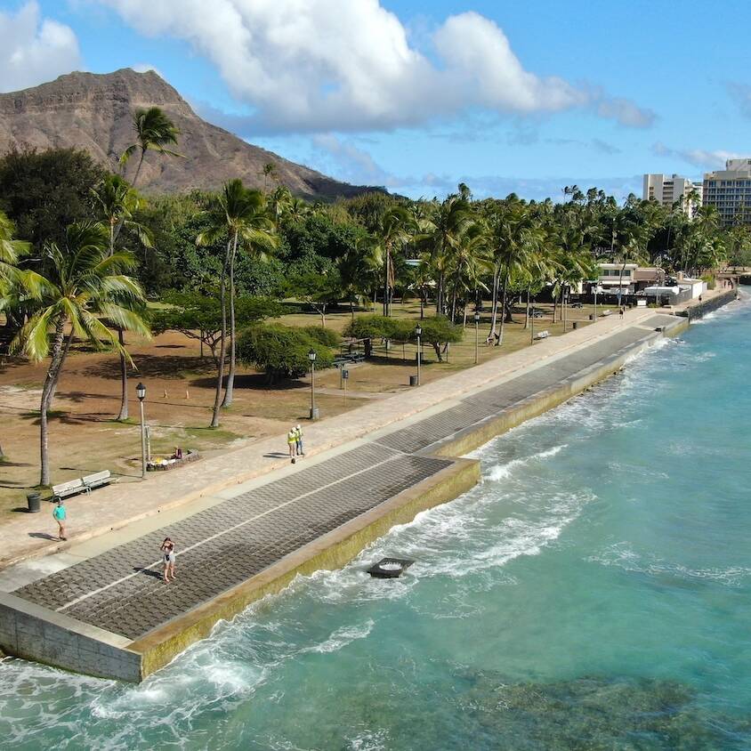 The Queens Beach Waikiki shoreline with an installed seawall and Diamond Head in the background