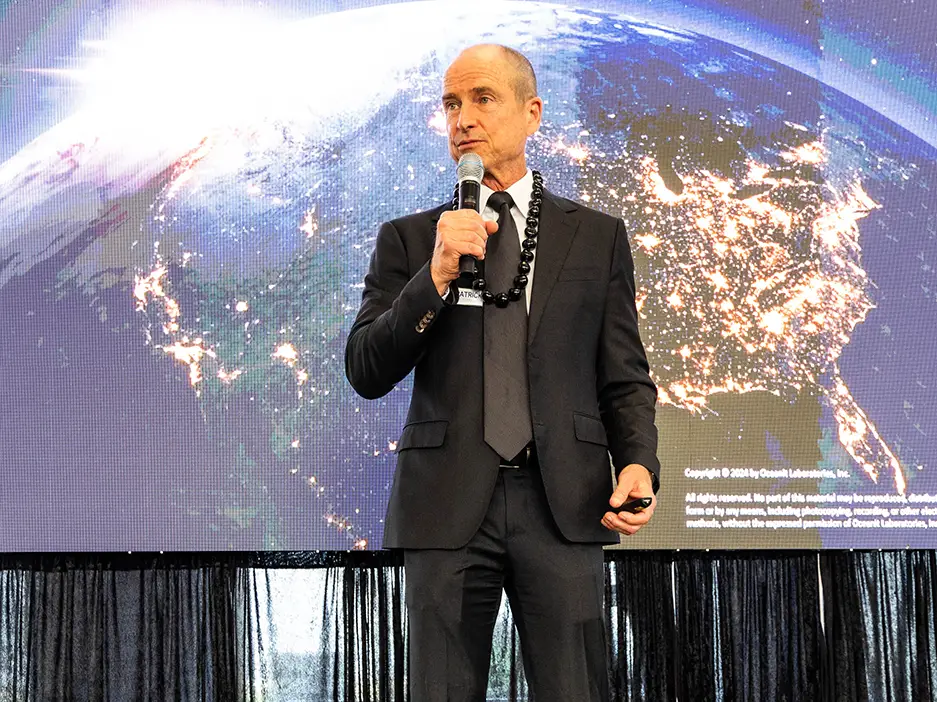 Patrick Sullivan on stage in front of a slide which reads Oceanit Technology Showcase