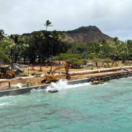 Queen's Beach Waikiki seawall with a wave crashing into it