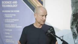 Patrick Sullivan speaking on a podcast microphone in the Oceanit office