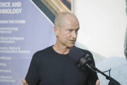 Patrick Sullivan speaking on a podcast microphone in the Oceanit office