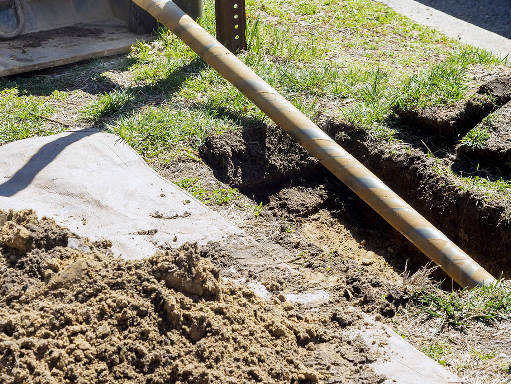 A trenchless horizontal drilling rig near a city sidewalk