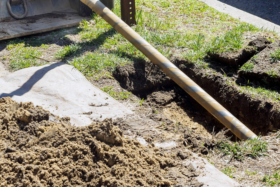 A trenchless horizontal drilling rig near a city sidewalk