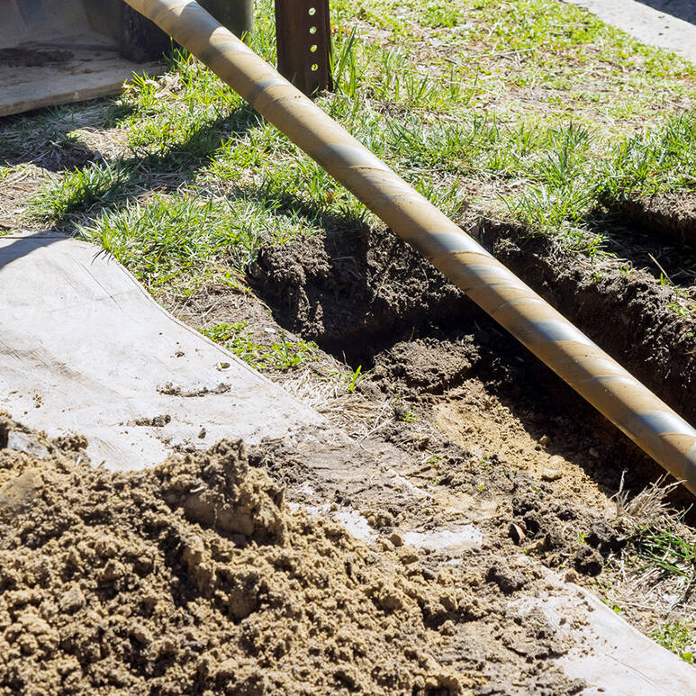 A trenchless horizontal drilling rig near a city sidewalk