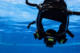 A universal breathing mask floating in a pool of blue water