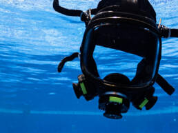 A universal breathing mask floating in a pool of blue water