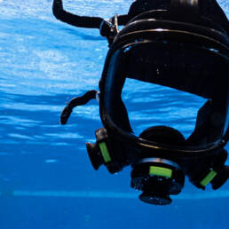 A universal breathing mask floating in a pool of blue water