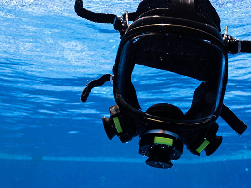 A universal breathing mask floating in a pool of blue water