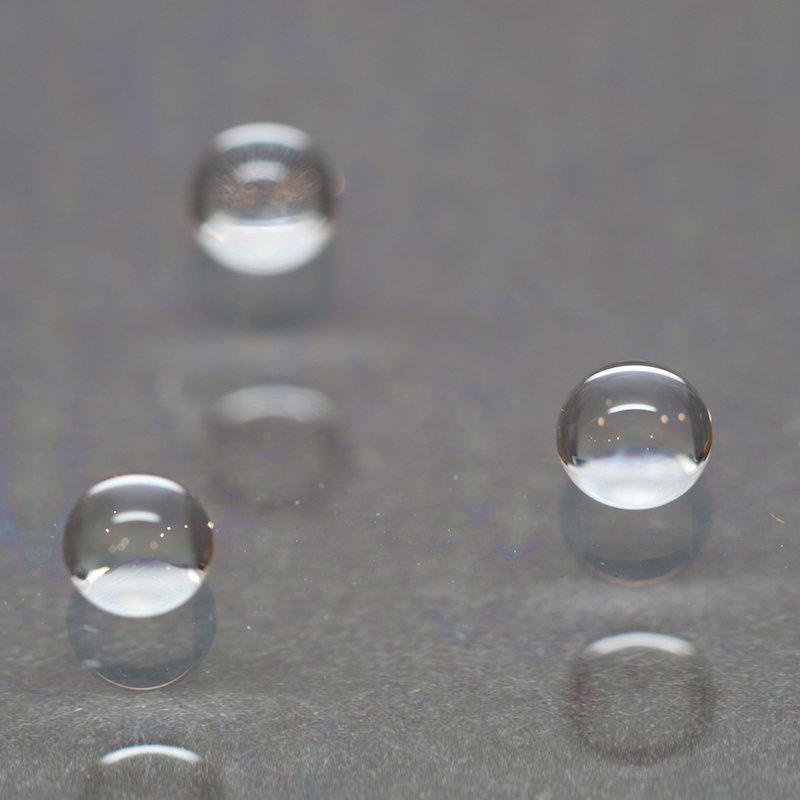 Drops of water beaded up on a gray glossy surface