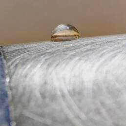 A droplet of water sitting on a metal surface