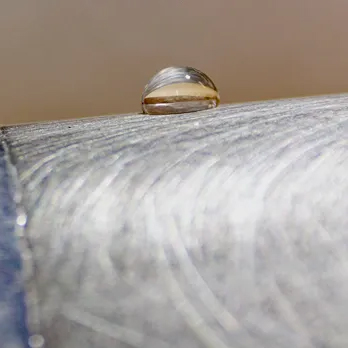 A droplet of water sitting on a metal surface