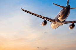 A plan flying away from the camera into a sunset