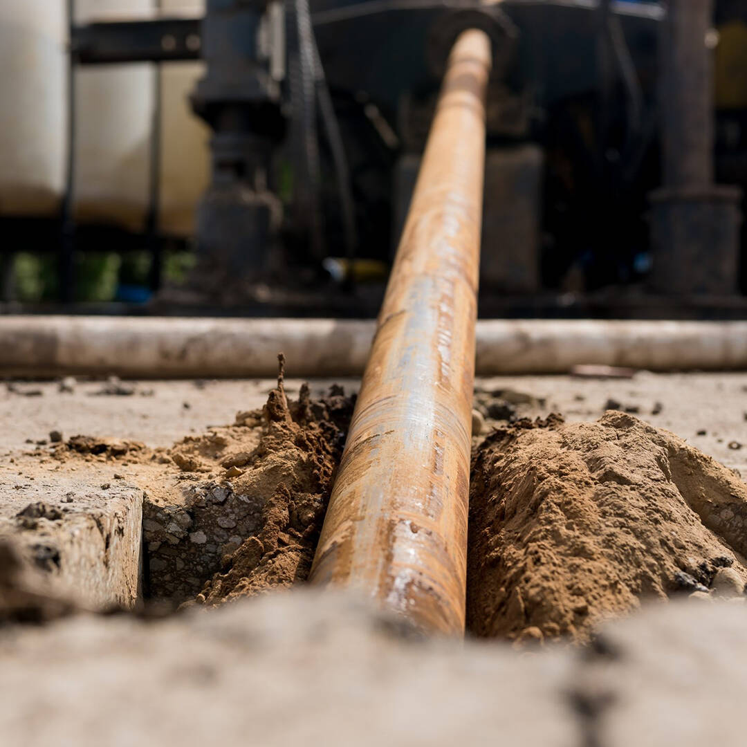 A large cable being inserted horizontally underground