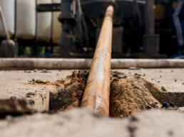 A large cable being inserted horizontally underground