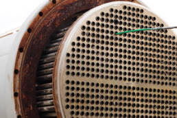 A rod sticking out of one of many holes in a heat exchanger front