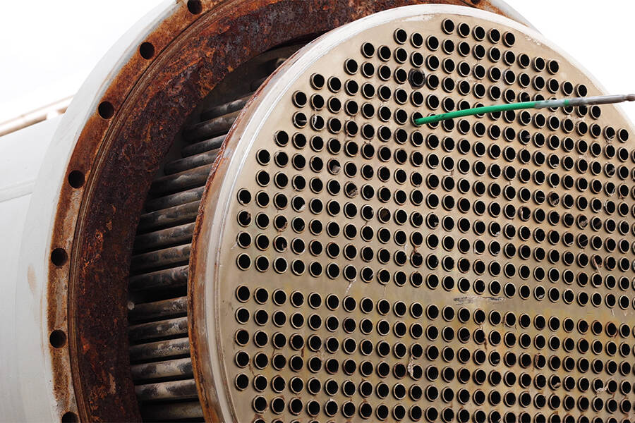 A rod sticking out of one of many holes in a heat exchanger front