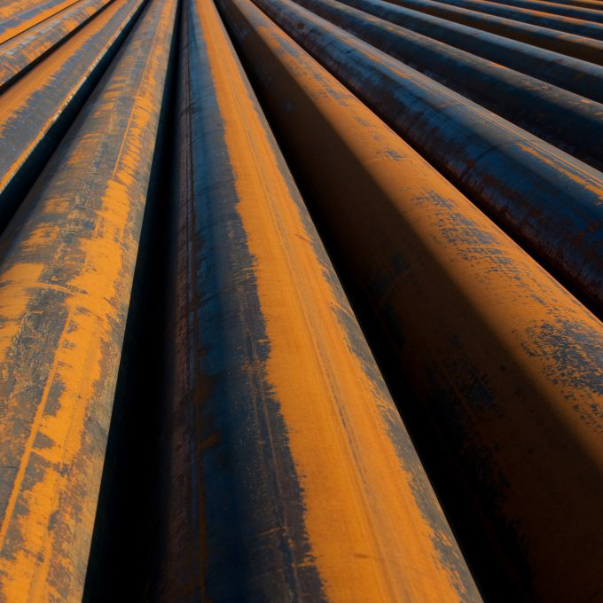 A row of rusted pipes in an industrial environment